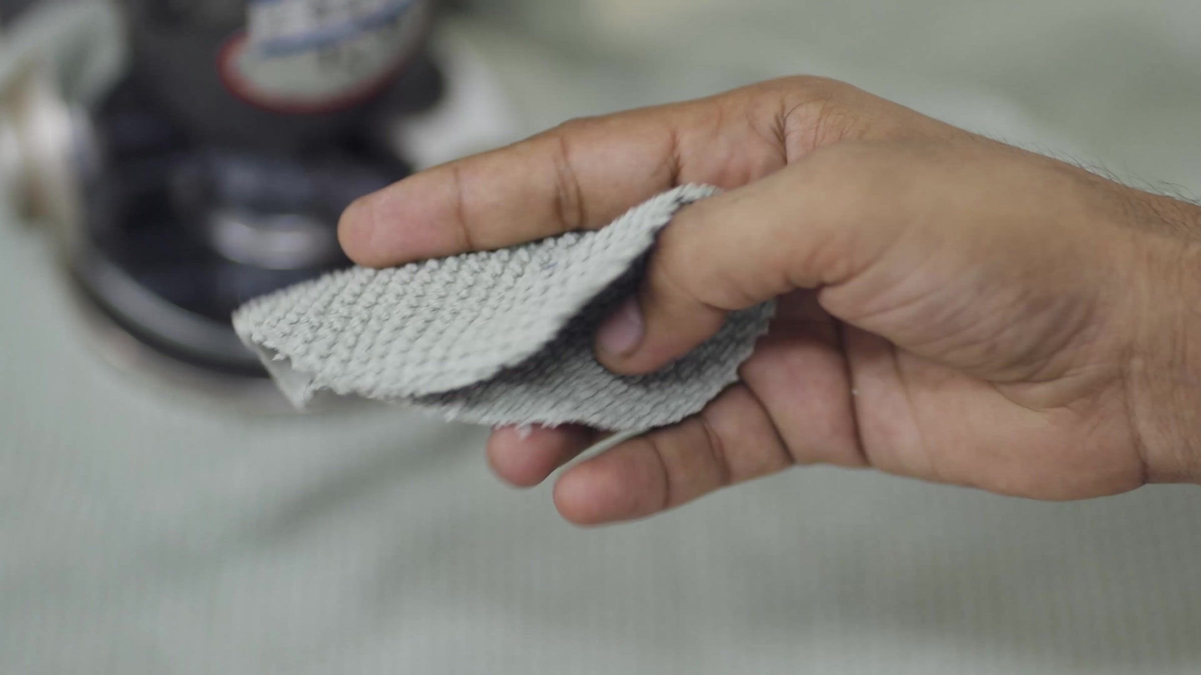 The disc of cloth cut by the GSM cutter, held in the hand beside it.