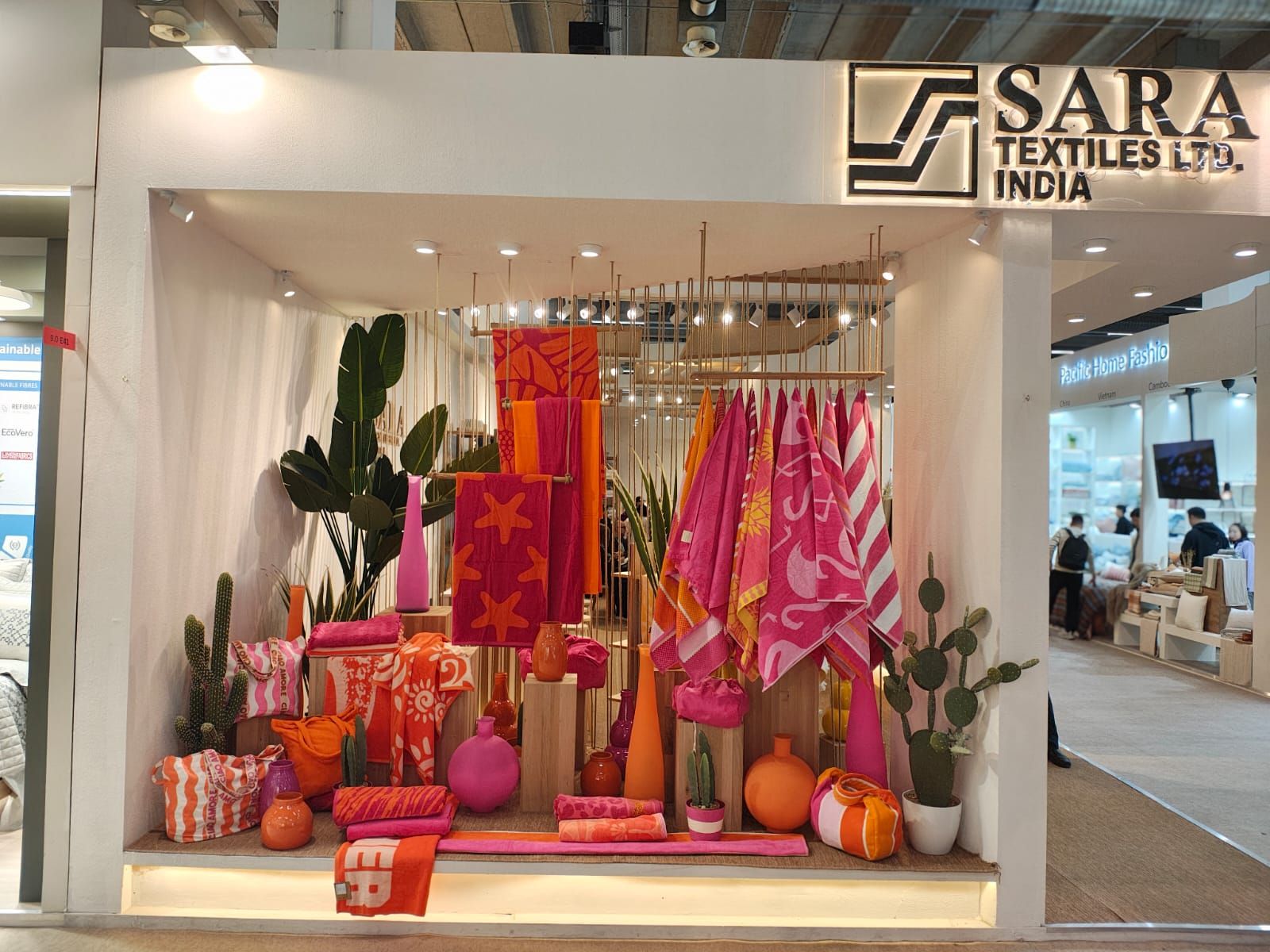 The stand at Heimtextil, a bay of pink and orange beach towels lit beneath the Sara Textiles sign.