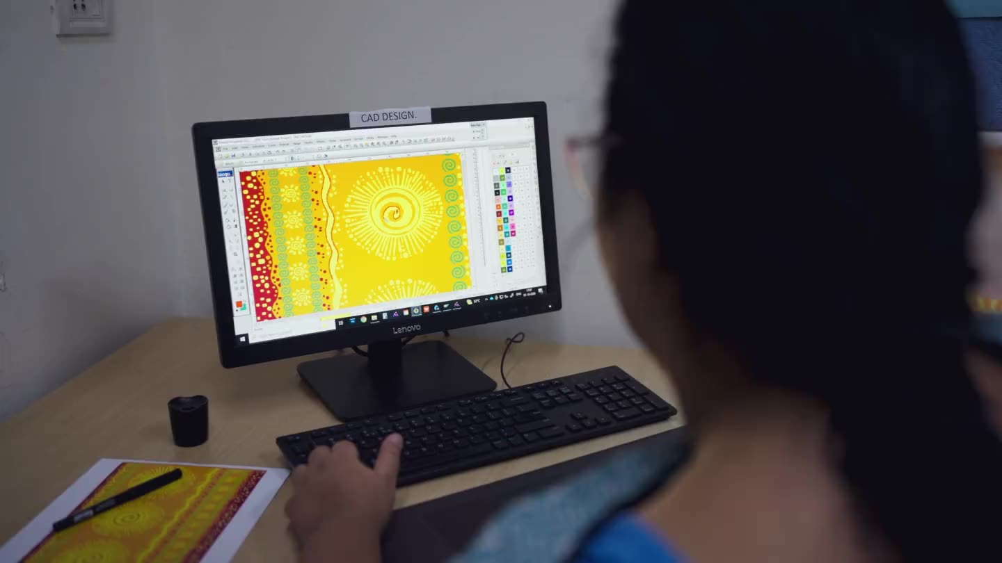 A designer working up the sun motif in the studio's CAD software, the artwork on screen in front of her.