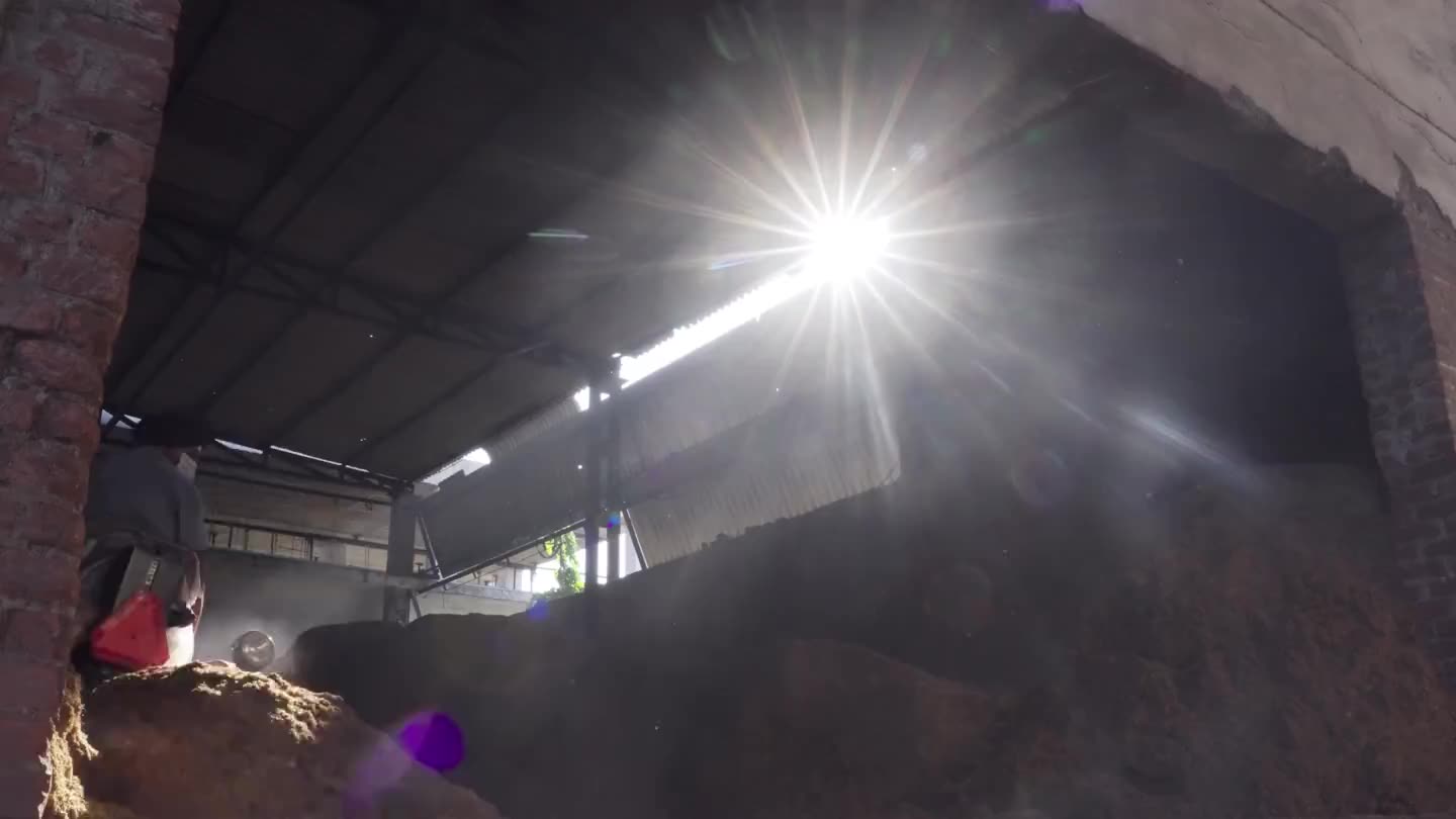 A loader moving rice husk inside the husk store.