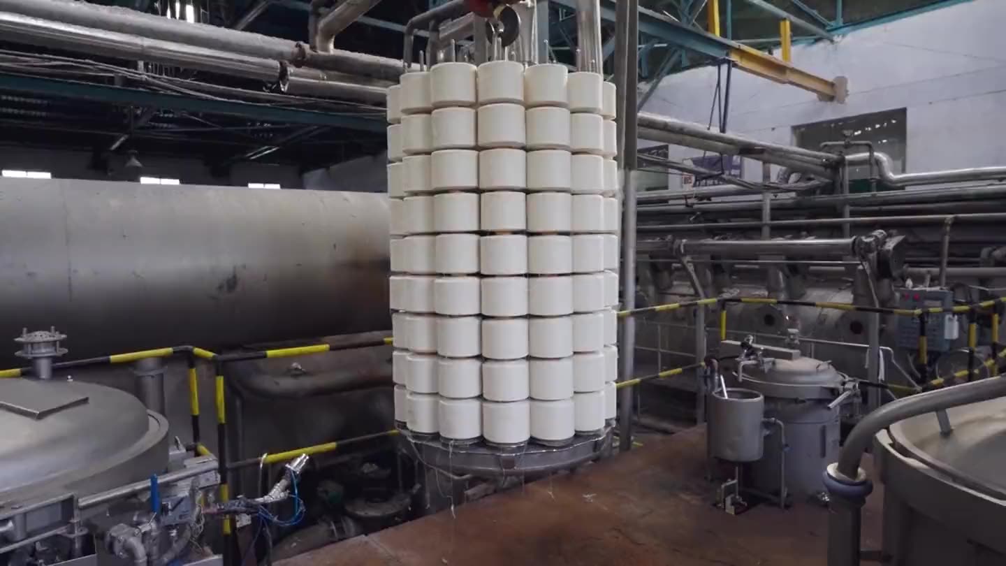 A carrier of undyed packages craned into the dye house, and the same carrier lifted out dyed.